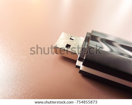 Close up black USB memory Flash Drive selective focus on brown background copy space technology concept save data