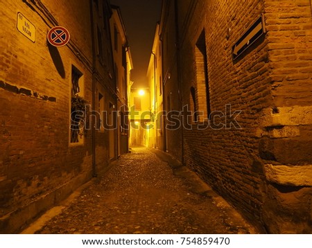 Ferrara, Italy. Medieval zone, 
photo shot at night. The sign tells the street name.