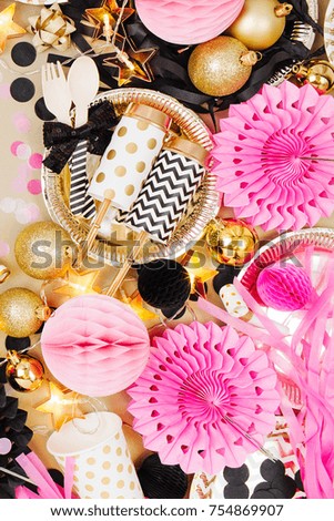Frame made of christmas balls with decoration stuff in golden, black and pink colors.  Flat lay, top view