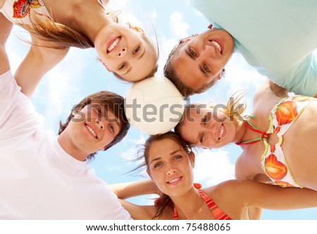 Below view of joyful teens looking at camera with smiles
