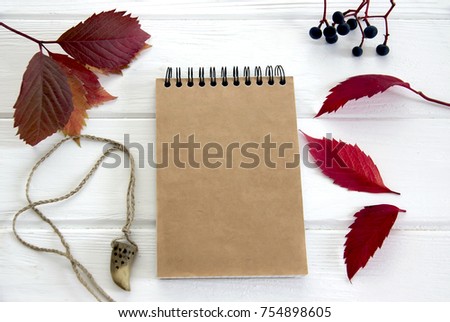 Trendy and Elegant mock up for visualization for private business. Vintage notepad, red leaves of grapes,celtic amulet for luck and craftsman tools on a white background vintage table.