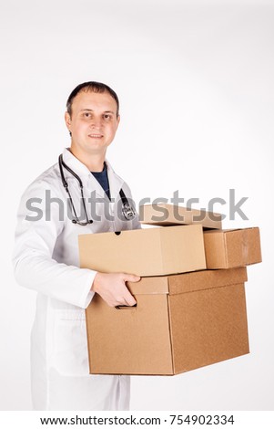 male doctor smiling, holding box and looking at camera. image on a white studio background.