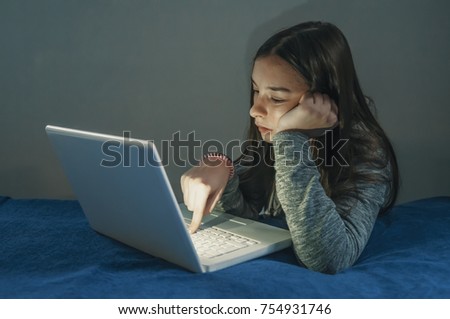 Teenager girl play online game on laptop. Teenage Girl Using Laptop To Do Homework In Bedroom. Unhappy Teenage Girl Using Laptop At Home. Thoughtful girl looking at screen 