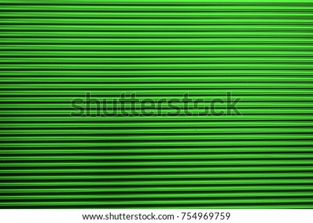 Metal corrugated background with free space for text. Green wavy grooved metal texture, copy space