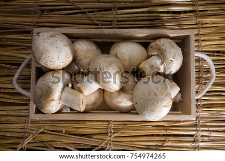 Fresh white mushrooms in a wooden crate, Champignons de Paris.