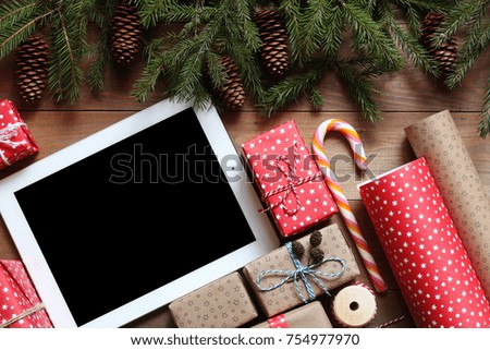 Tablet and Christmas gifts on a wooden table