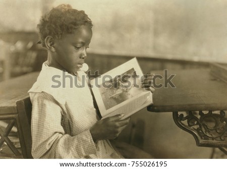 Young girl reading an illustrated book in Pleasant Green School, near Marlinton, West Virginia. The one-room school was one of the best schools for African Americans in Pocahontas County. Oct. 1921. P Royalty-Free Stock Photo #755026195