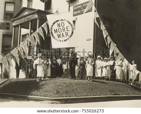 Raising the 'No More War' banner over the HQ of the Council for Limitation of Armaments. July 29,1922. Attending are mostly women, in Washington, D.C. The Council shared a building with the National L