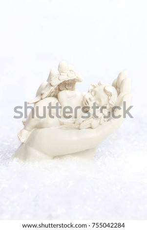 Angel resting in the loving hand of maria in a snow setting