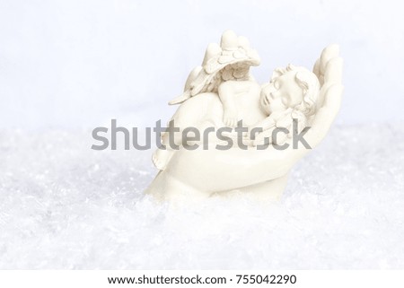 Angel resting in the loving hand of maria in a snow setting