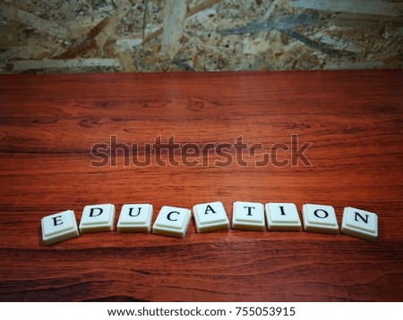 Education in alphabetical cube concept. Isolated on wooden surface and wall.
