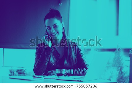 Beautiful girl working out a plan of the project and concept. Girl paints a website design on a laptop. student prints a message on the phone in the messenger. Digital marketing. Overlay color
