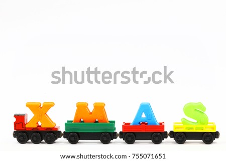 Alphabet x mas in red, green and blue color on the red, green and yellow train toy, isolated on white