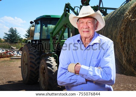 Elderly Farmer working with his tractor on the farm