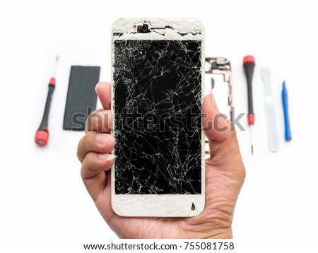 Close-up of cracked smartphone screen in technician hand on blurred smartphone component background