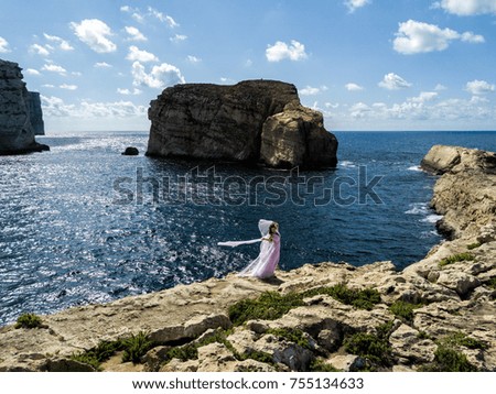 Woman in wedding dress on the rugged Mediterranean Sea coast.  Island of Gozo, Malta