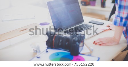 Female photographer sitting on the desk with laptop . Female photographer