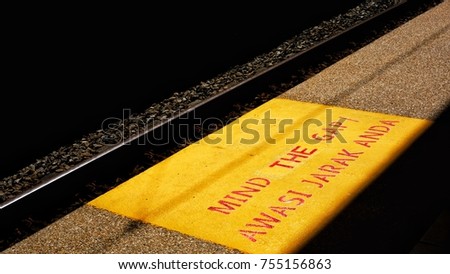 A floor at railway station with yellow box contain words "Mind The Gap" in english language or "Awasi Jarak Anda" in malay language Royalty-Free Stock Photo #755156863