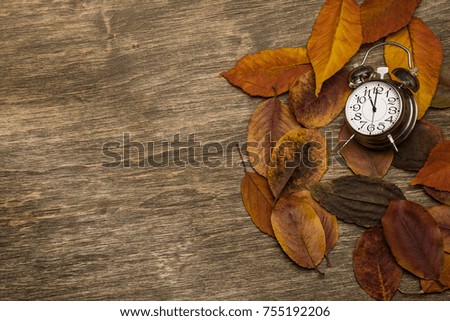 Old clock on a background of yellow leaves