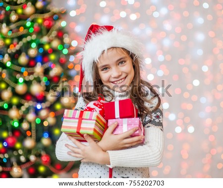 Happy little girl holding many present boxes