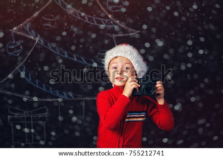 Boy with old camera on Christmas background
