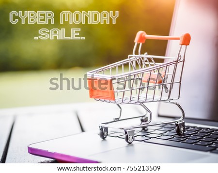 Mini shopping cart and laptop for Cyber Monday sale concept.