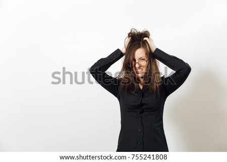 The pretty European young angry brown-haired woman in glasses for sight with healthy clean skin, dressed in a dark black shirt, screaming and swearing, on a white background. Emotions concept.