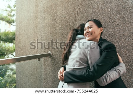 two happy confident Asian hugs together to celebrate the successful project finished outside of office. Royalty-Free Stock Photo #755244025