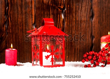 Christmas and New Year background with Christmas candle lantern and Christmas tree branches, snow and decorations, wooden wall behind. Free space