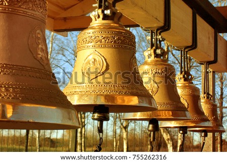 Church orthodox bells on the street on the background of trees and blue sky
