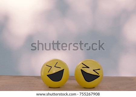 Two sad crying face yellow ball on wooden table and bokeh wall with copy space
