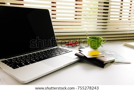 Office desk with laptop, coffee cup,Magnifying glass,Credit Cards,Passsport,on the wooden floor.