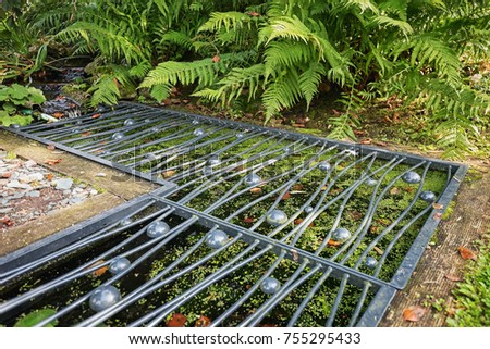 Pond covered with a decorative iron grid.