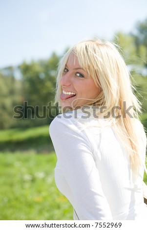 Blond haired woman sticking out her tongue.