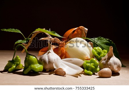 Onion with garlic and pepper on a dark background