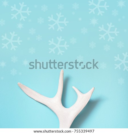 White painted deer antlers on a blue background. Square image. Christmas concept with copy space.
