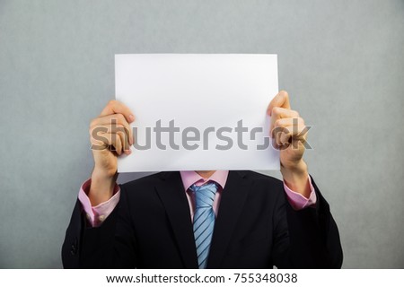 Man in suit with a blank sheet of paper in his hands