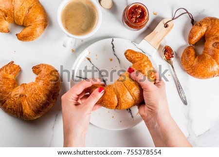 Girl eats homemade continental breakfast, croissants, coffee. jam on white marble table, copy space top view, hands in picture