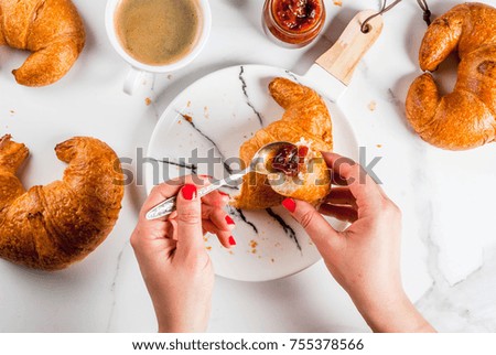 Girl eats homemade continental breakfast, croissants, coffee. jam on white marble table, copy space top view, hands in picture