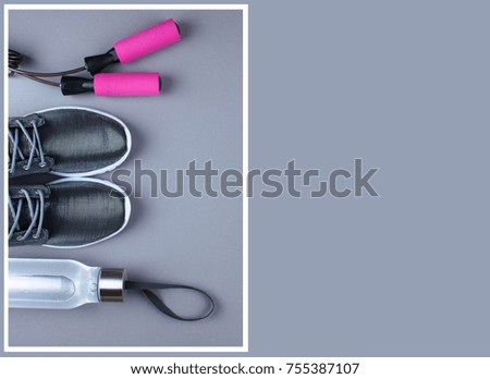 Flat lay shot of sneakers, jumping rope and dumbbells on gray background with copy space for your text. 