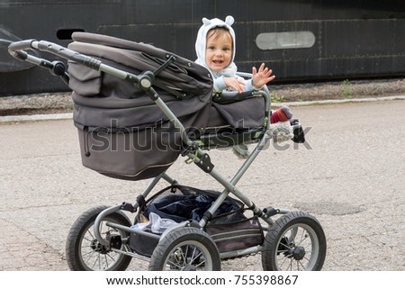 a boy in a baby stroller with funny ears