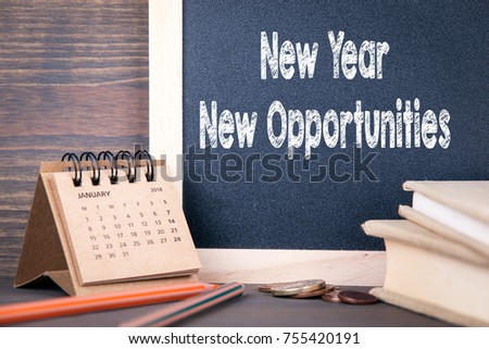 new year new opportunities. paper calendar and chalkboard on a wooden table