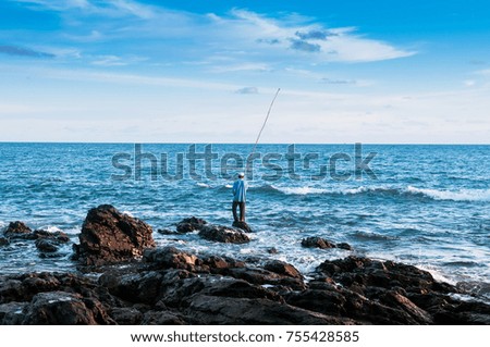 Local fisherman is fishing with bamboo fishing rod in the evening at Nui beach on Koh Lanta, Krabi, Thailand
