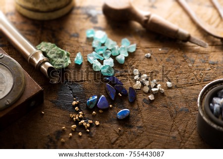 Exploring mining, and inspecting gems. Treasure hunting. Gold and gems on rough wooden surface. Royalty-Free Stock Photo #755443087