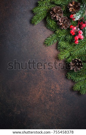 Christmas background. Fir tree pine cones and decorations on dark stone table. Top view with copy space. Vertical.