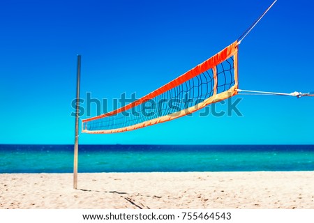 Volleyball net and empty beach. Sea Beach and Soft wave of blue ocean.  Summer day and sand  background. 
