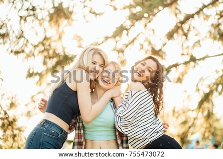 Two happy affectionate young woman hugging each other in a close embrace while laughing and smiling Royalty-Free Stock Photo #755473072