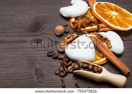 Christmas background: white gingerbread cookies, dried orange, cinamon, anise and cloves on dark brown wooden plank, copy space