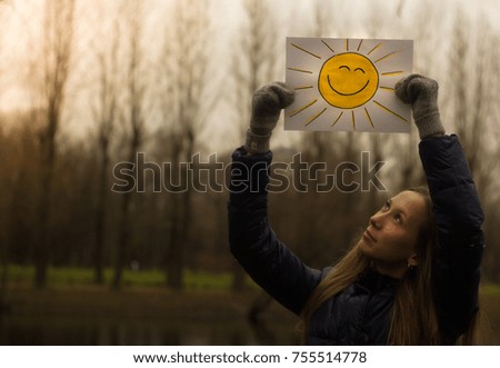 Girl holding a picture with a smiley face