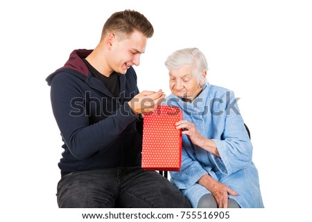 Picture of an old lady receiving birthday gifts from her grandson